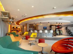 una sala de espera con mesas y sillas coloridas en ibis Styles Lima Benavides Miraflores, en Lima