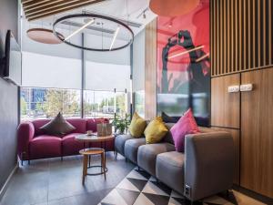 a living room with purple couches and a table at Ibis Aktobe in Aktobe