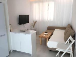 - un petit salon avec un canapé et une table dans l'établissement Casita cerca de la playa decorada con amor, à Tarifa