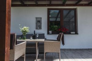 a dining table with chairs and a window at Erdőhangja Vendégház in Mikóháza