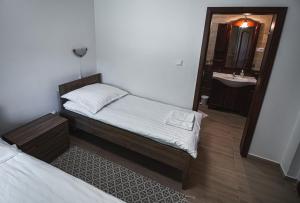 a small bedroom with two beds and a sink at Erdőhangja Vendégház in Mikóháza