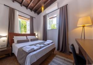 a bedroom with a bed with a desk and windows at La Regina Veneziana in Famagusta