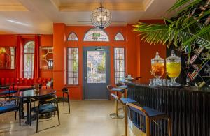 a restaurant with orange walls and tables and chairs at Villa Brown Moshava - a member of Brown Hotels in Jerusalem