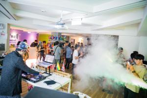 a group of people standing around a table with smoke at D'well Hostel in Kaohsiung