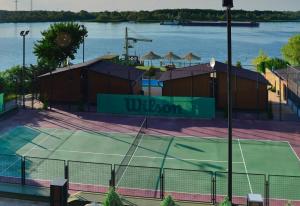 a tennis court next to a body of water at Holiday Village Katrin in Nova Kakhovka
