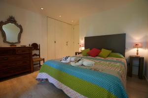 1 dormitorio con cama, tocador y espejo en Casa da lapa, en Paredes de Coura