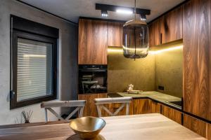 uma cozinha com armários de madeira e uma mesa com uma tigela em Bella Roe Premium Apartments em Belgrado