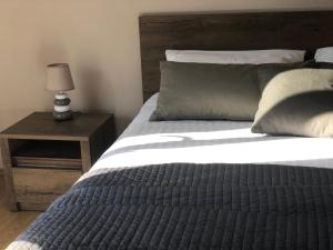 łóżko z drewnianym zagłówkiem oraz stół z lampką w obiekcie Bed & Breakfast Kurtic w mieście Supetar