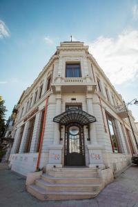 un gran edificio blanco con escaleras delante en Casa Hrisicos, en Constanţa