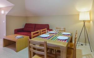 uma sala de estar com uma mesa e um sofá vermelho em Apartamentos Trisquel em Sanxenxo