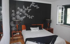 a bedroom with a bed with a black and white wall at Moradia Familia Escoto in Monsanto