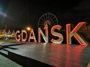 a large sign that says gamedik in front of a ferris wheel at Biała Perła Apartment in Gdańsk