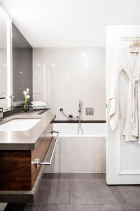 ein weißes Badezimmer mit einem Waschbecken und einer Badewanne in der Unterkunft David InterContinental Tel Aviv  in Tel Aviv