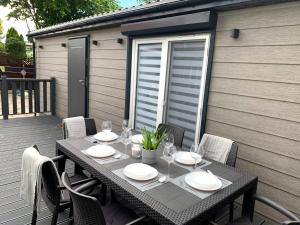 - une table avec des assiettes et des verres à vin sur la terrasse dans l'établissement Domki nad morzem, à Gdańsk