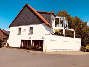 a white building with a black roof at Pension K.Krause in Salzgitter