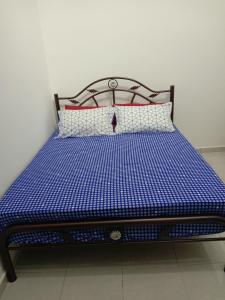 un letto in una camera di colore blu e bianco di Ros Residence ad Ayer Keroh