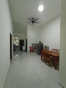 sala de estar con ventilador de techo y mesa en Ros Residence, en Ayer Keroh
