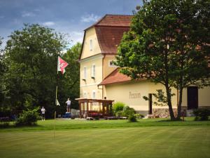 una casa con una bandera en un campo de golf en Penzion Černická obora, en Bechyně