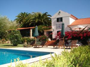 a house with a swimming pool and chairs and umbrellas at Quinta Verde Sintra - Casa de Campo in Sintra
