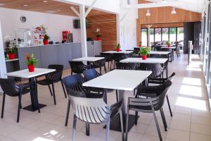 une salle à manger avec des tables et des chaises dans un restaurant dans l'établissement Village Vacances de Chantonnay, à Chantonnay