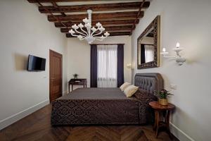 1 dormitorio con cama, espejo y lámpara de araña en Porta da mar, en Venecia
