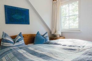 a bedroom with a bed with blue and white pillows at Ferienwohnung Strandperle in Prerow
