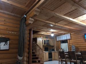 a living room with wooden walls and wooden ceilings at Коттедж Luky in Migovo