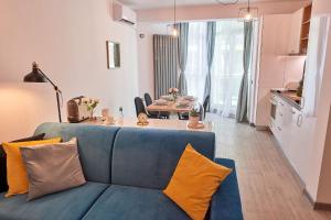 - un salon avec un canapé bleu et une table dans l'établissement Vanilla Luxury Apartment Spa n Pool beach resort, à Mamaia Nord – Năvodari
