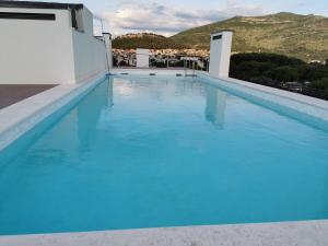 une grande piscine d'eau bleue au-dessus d'un bâtiment dans l'établissement Travunia Lux Residence With The Pool on The Rooftop, à Trebinje