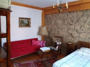 a living room with a red couch and a bed at Apartmani Memory in Višegrad