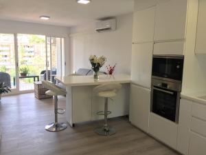 a kitchen with a counter and a table with stools at Panoramic Apartments Sitges in Sitges