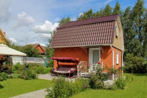 希姆基的住宿－U Istoka Homestay，一座红色的小房子,在院子里设有长凳