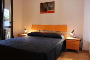 a bedroom with a large bed and two lamps at Villa delle Sirene in Ascea