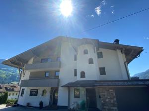 a white building with the sun in the sky at Ferienhaus Edith in Kaltenbach