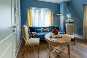 a living room with a blue couch and a table at House of Hütter - Heidelberg Suites & Spa in Heidelberg