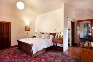 1 dormitorio con cama, mesa y espejo en Brooklyn Manor, en Pretoria
