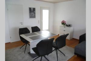 a dining room with a white table and black chairs at Ferienwohnung nördliches Münsterland in Greven