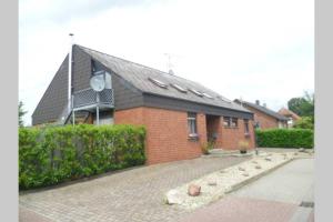 a brick house with a brick driveway in front of it at Ferienwohnung nördliches Münsterland in Greven