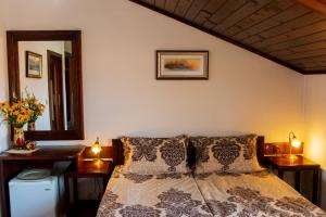 a bedroom with a bed with two night stands and a mirror at Grancharova Guest House in Bansko