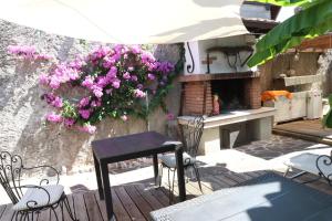 una mesa y sillas en un patio con flores en B&B Casa Elena Room and Apartments with parking, en Gargnano