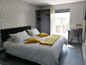 a bedroom with a bed with yellow pillows on it at Cosgrove Inn in Scunthorpe