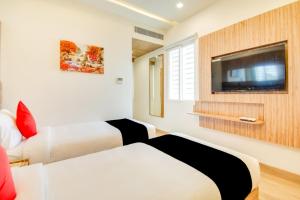 a hotel room with two beds and a flat screen tv at INN THE CENTRE in Nellore