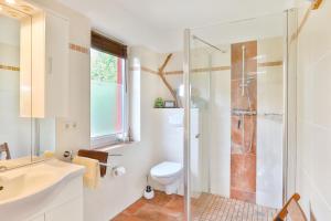 een badkamer met een douche, een toilet en een wastafel bij Ferienhäuser Fuchsweg in Stralsund