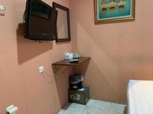 a bedroom with a tv on the corner of a wall at Hotel Rumah Shinta in Jakarta