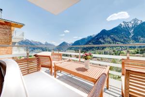a balcony with a table and chairs and mountains at Appartement Valbona Blick by A-Appartments in Bürserberg
