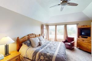 a bedroom with a bed and a tv and a chair at Skier's Four-Leaf Clover in Cottonwood Heights