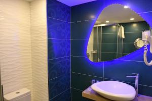 a bathroom with a sink and a mirror at Hôtel Le Claridge in Propriano