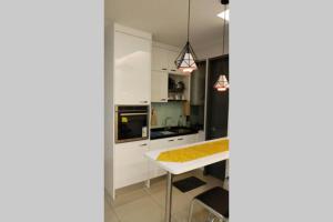 uma cozinha com armários brancos e uma mesa branca em Comfortable and relax, Netflx and Wi-Fi provided em Batu Caves