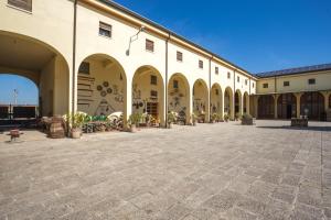 a courtyard of a building with arches and tables at Agriturismo Corte Carezzabella in San Martino di Venezze