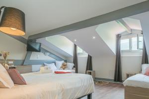 een slaapkamer met een groot bed op zolder bij Hôtel du Pont in Ascain